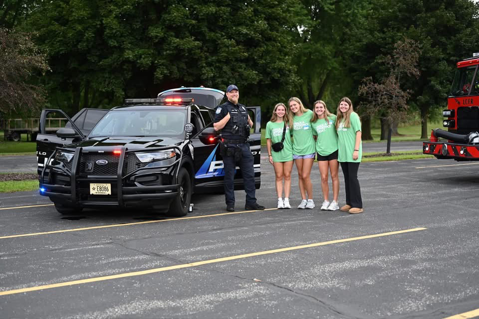 S.E.R.V.E. volunteers at a community touch-a-truck event with police and fire vehicles