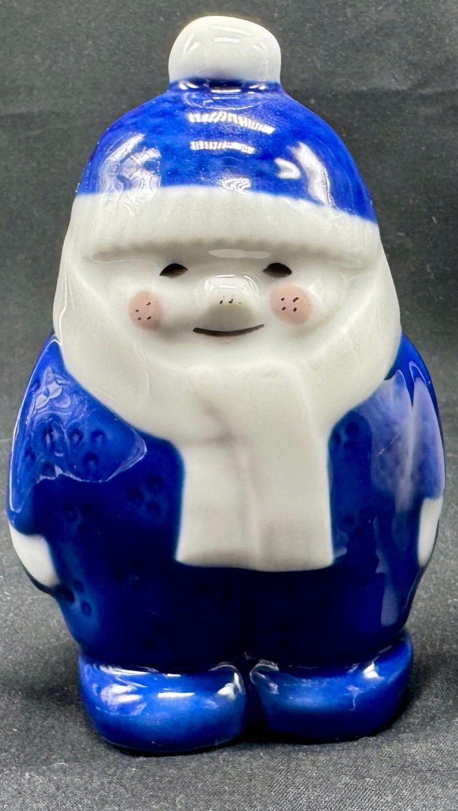 Miniatyrbilde: En smilende, blåhvit keramikkfigur med vinterlue og skjerf.