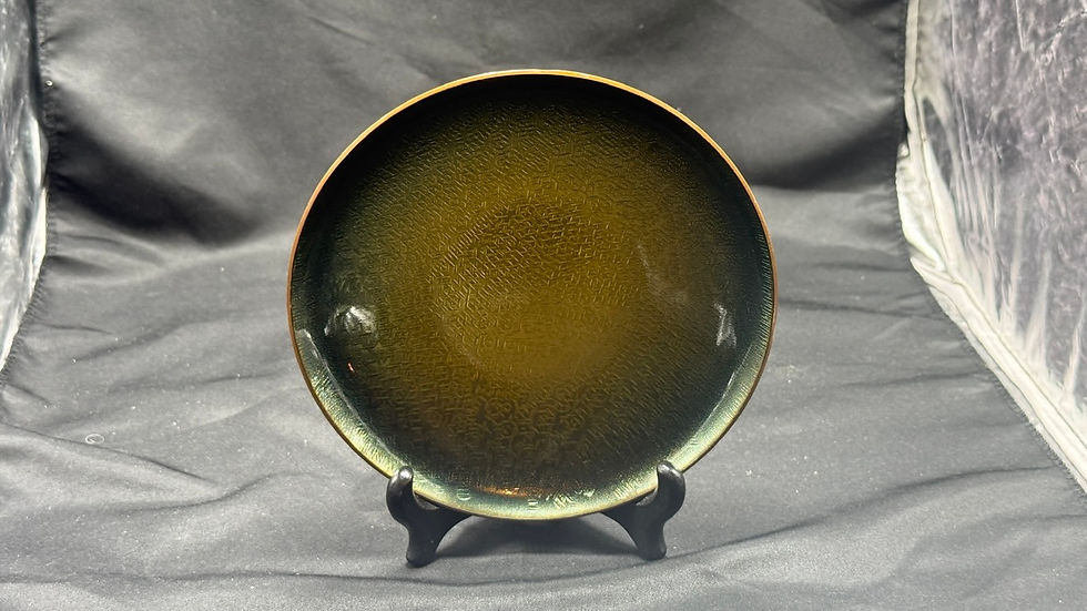 Miniatyrbilde: Mørkegrønt, flekkete keramikkfat på svart stativ mot mørk bakgrunn.