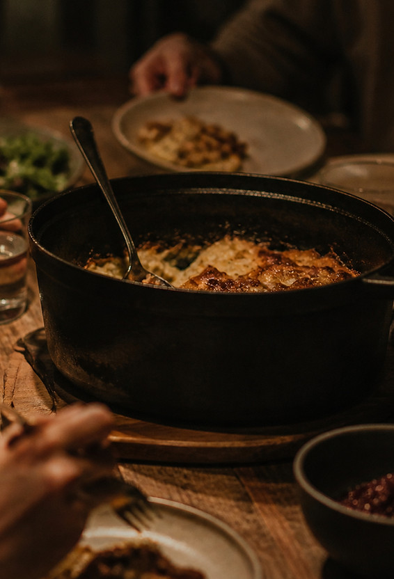 Gusseiserner Topf auf Holztisch mit ehrlichem Catering