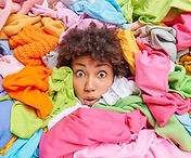 overwhelmed-afro-american-woman-gives-advice-recycle-your-old-clothes-sticks-out-head-thro