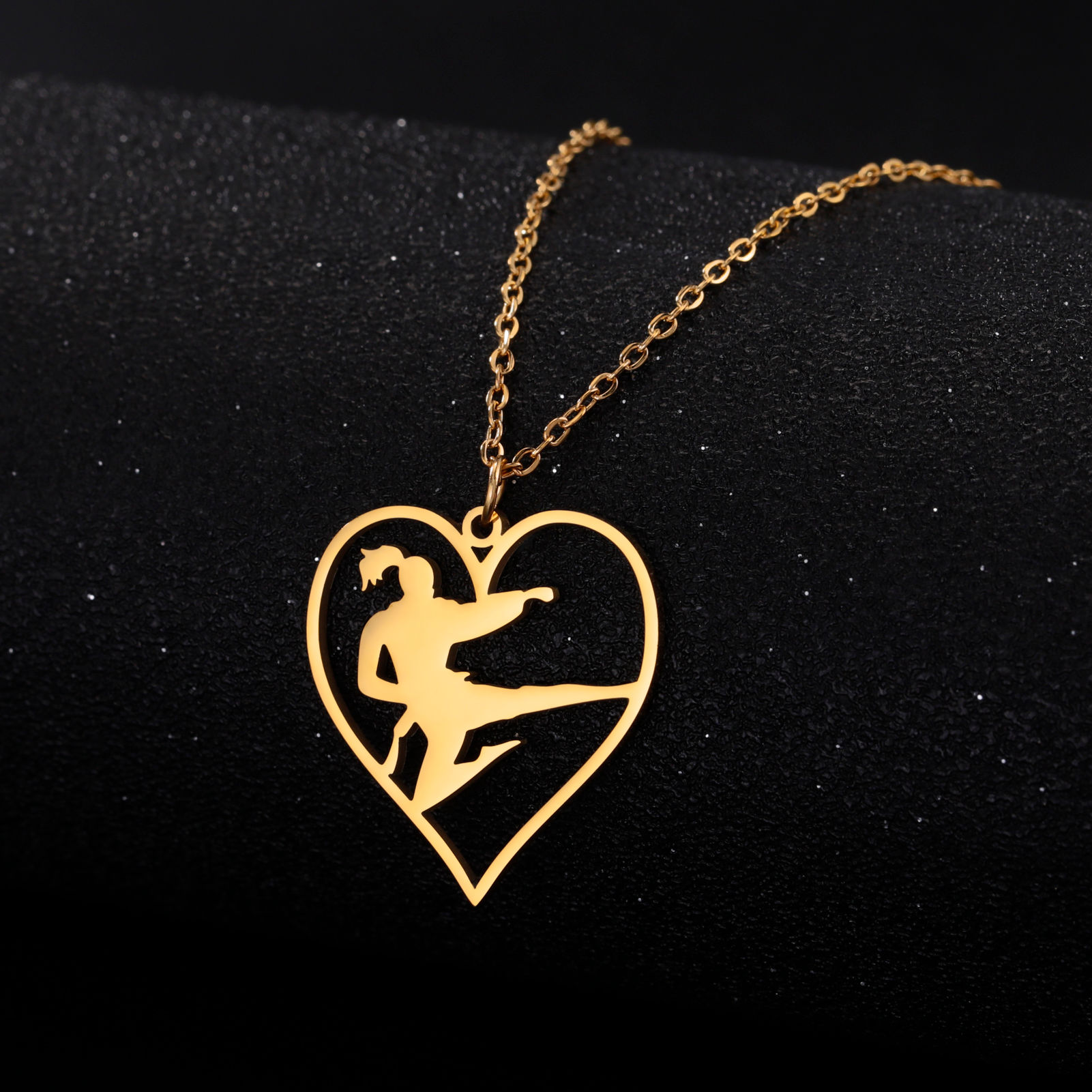 Gold heart pendant with martial arts kick silhouette