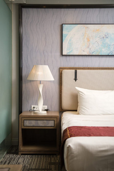 A detailed photo of the bed in a Standard King room and the nightstand with the lamp in Sunlight Hotel Puerto Princesa