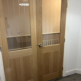 A wooden bi-fold door with a glass panel
