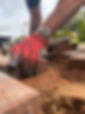 Man placing brick on the ground