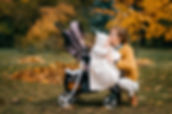 Lady kissing her baby on a pram