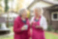Two happy women stand outside