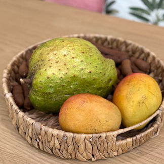 Soursop and mangoes on a basket-woven tray
