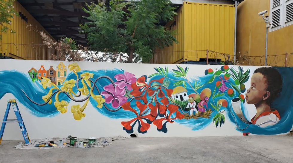 customized mural from a child who is blowing life onto the wall with a lot of colours and kunuku houses