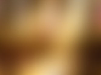 Sonnenlicht fällt durch mehrere große, bunte Kirchenfenster und wirft farbige Lichtstrahlen in das Innere einer alten Steinkirche. Im Vordergrund stehen Holzbänke, im Hintergrund sieht man einen schlichten Altar mit Kerzen und Kreuz. Die Atmosphäre wirkt ruhig, warm und einladend.