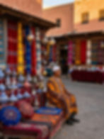 Man in traditional attire at a vibrant marketplace