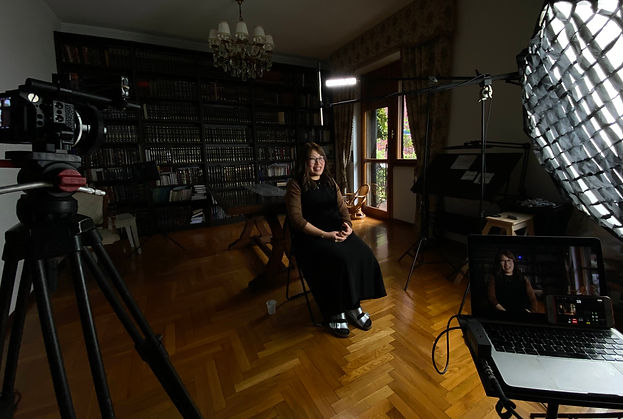 Behind the scenes of a documentary interview shoot in Milan, showing the lit set and camera setup