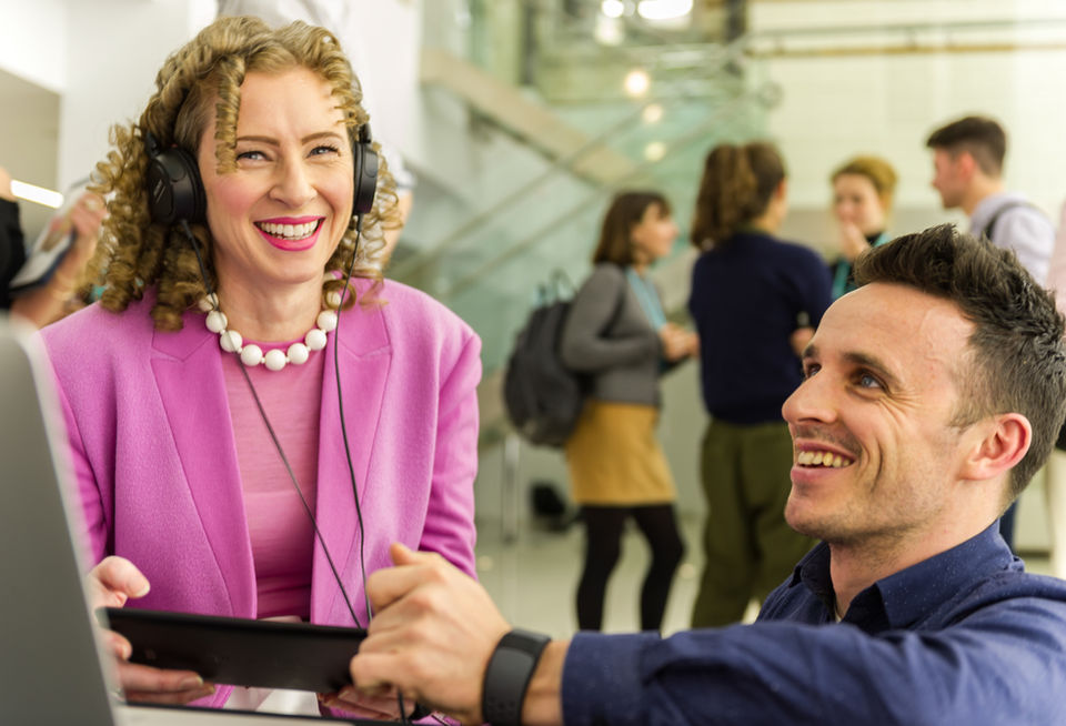 Photo of two business people interacting with a laptop based demo at a conference in London