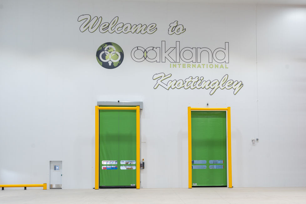Branded internal wall with green loading doors inside Oakland International Knottingley warehouse