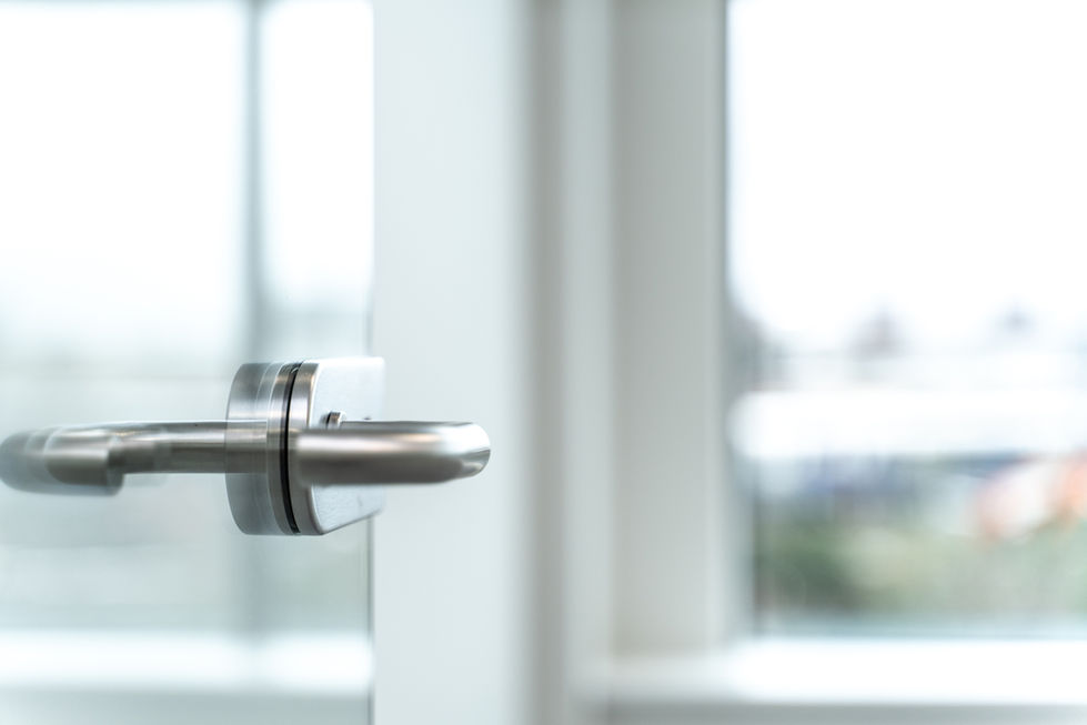 Stainless steel ironmongery detail on a glazed internal office door