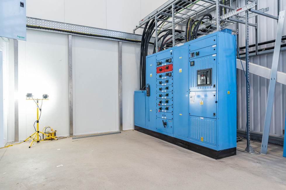 Blue electrical switchgear installation inside modern warehouse services area