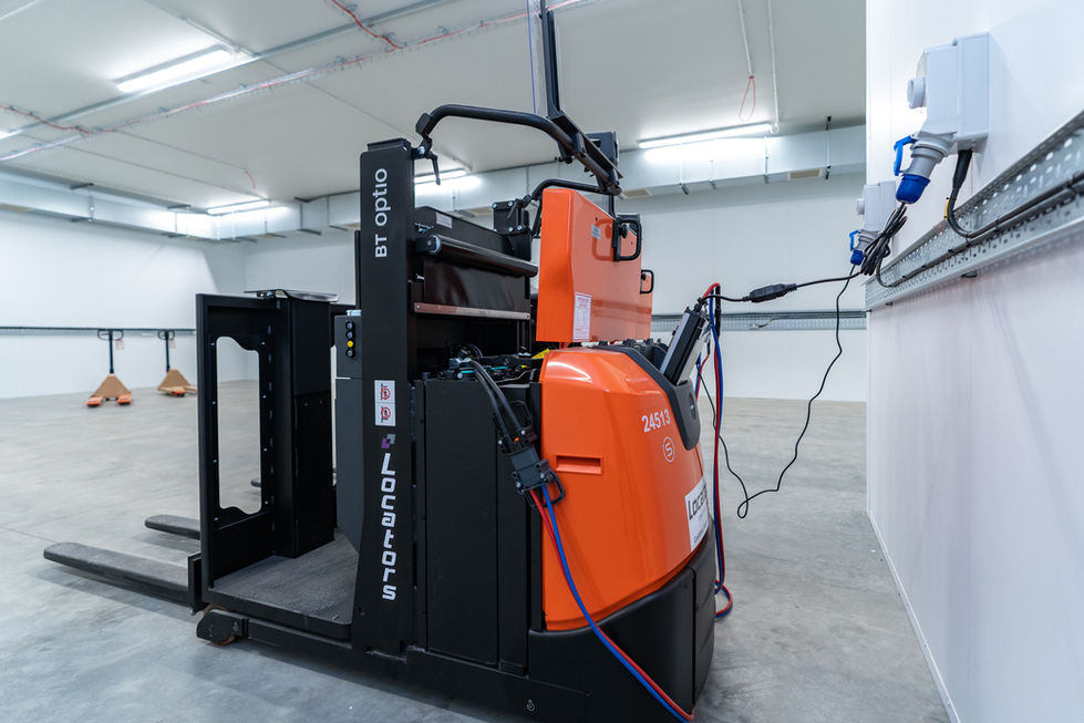 Electric pallet stacker charging point within warehouse operational area