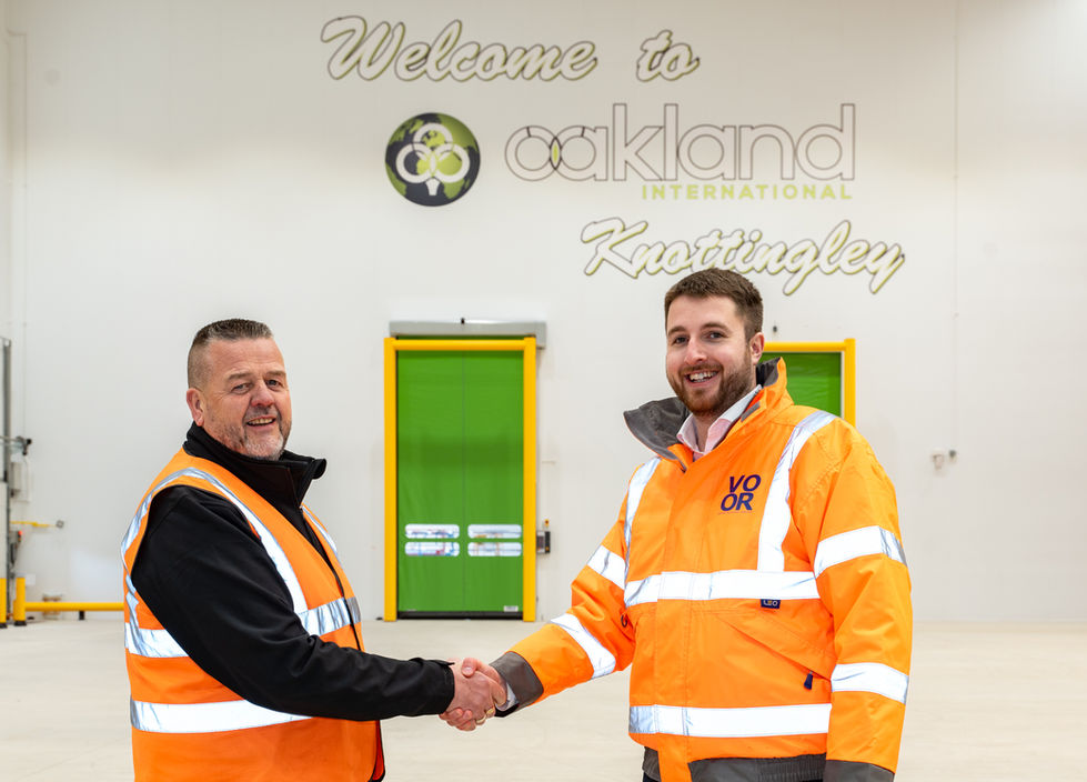 Two team members shaking hands inside completed warehouse facility