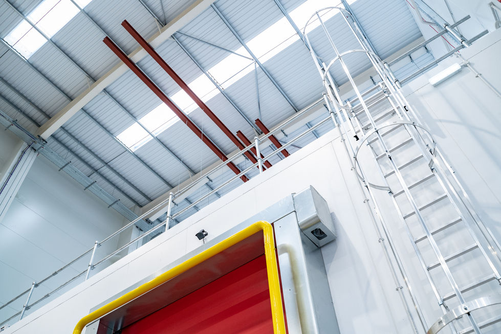 Ladder access and high-level platform above red rapid door within warehouse fit-out
