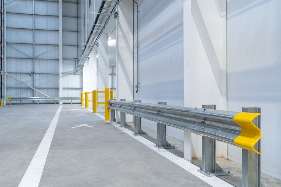 Warehouse wall protection barrier and yellow bollards within logistics facility