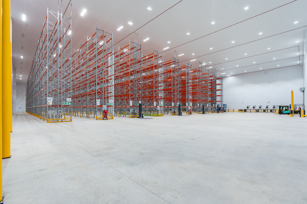 Wide interior view of completed warehouse with high bay racking and open floor area