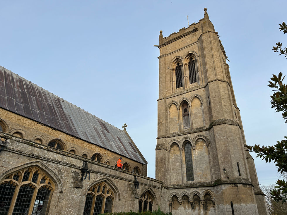 Surveyor on the aisle roof at St Mary’s Church, Whaplode, beside the church tower