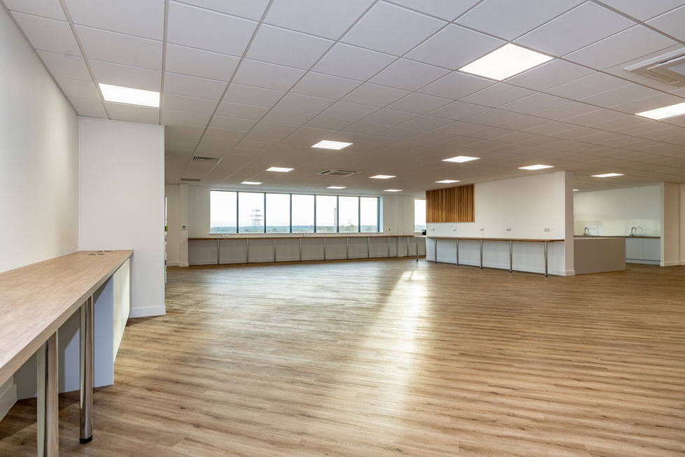 Modern staff breakout area with open-plan layout, timber flooring and full-height windows