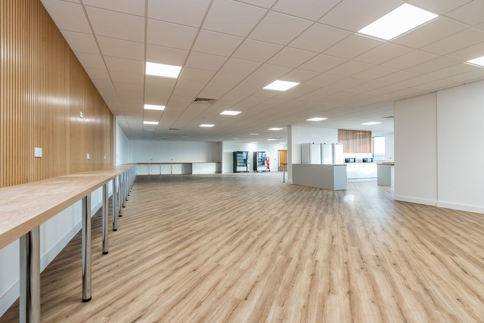 Modern staff breakout area with timber flooring, kitchen and open seating space