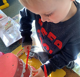 Child prushing a set of play teeth