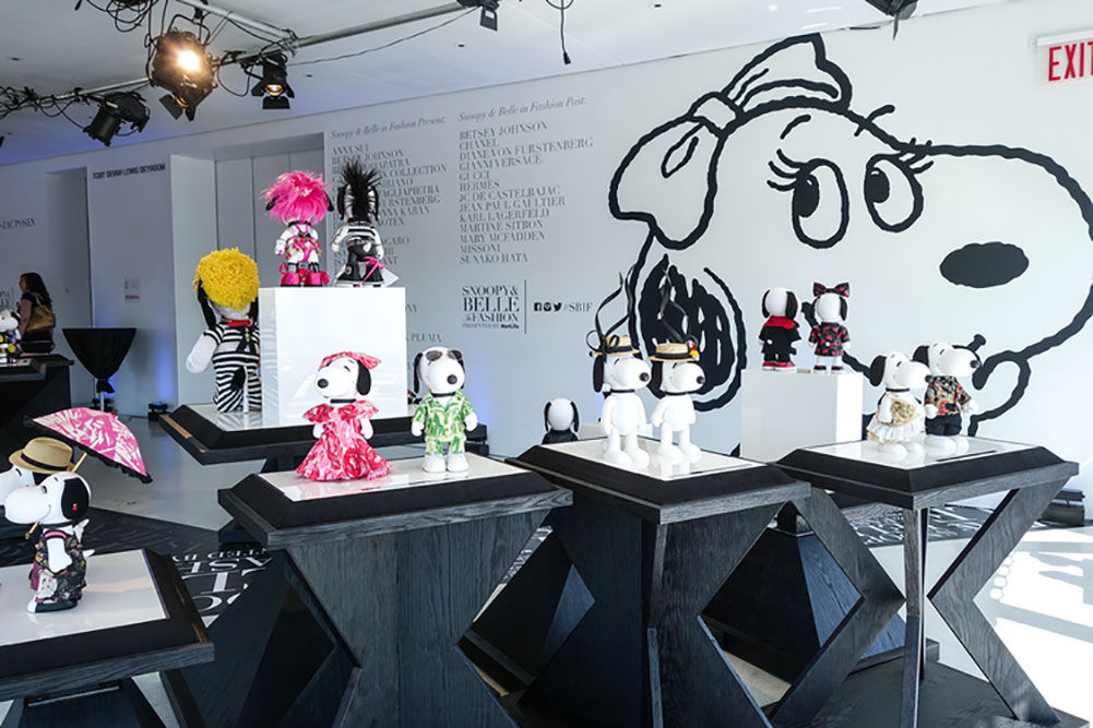 a display of dog statues wearing different colorful outfits