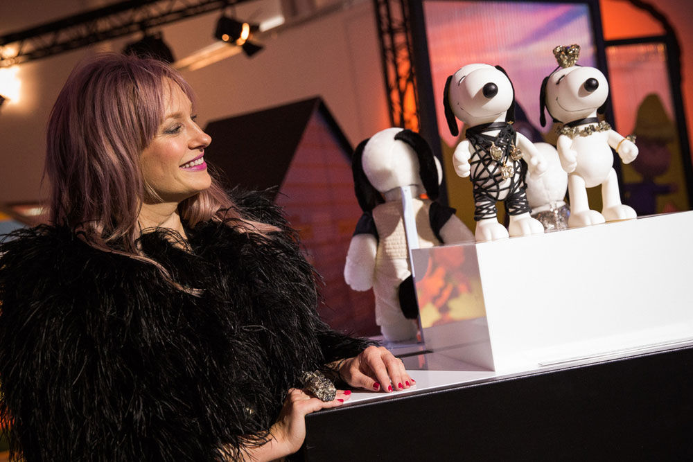a woman is smiling upon looking at dog figurines on display