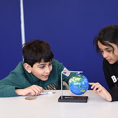 a boy and a girl playing with a world globe.