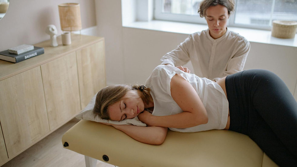 A woman receives a therapeutic massage from a specialist indoors.