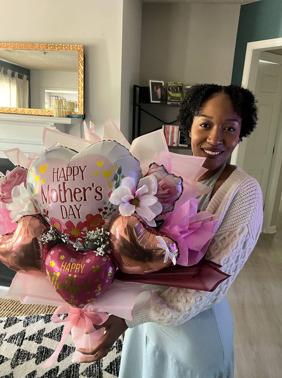 Smiling woman with a large Mothers Day balloon bouquet bloo