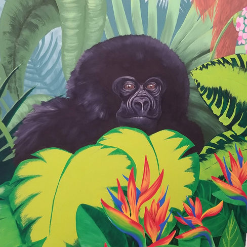 hand painted mural featuring a baby gorilla behind large leaves in the jungle