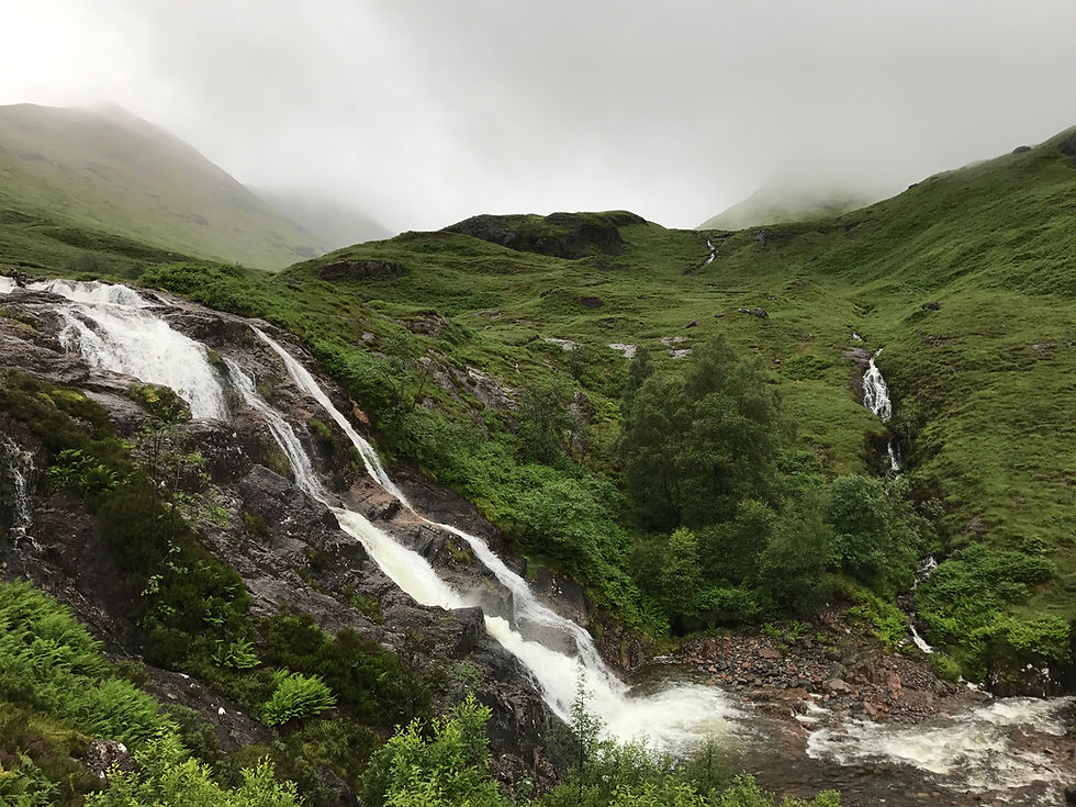 waterfalls coming from green hills in the Scottish Highlands