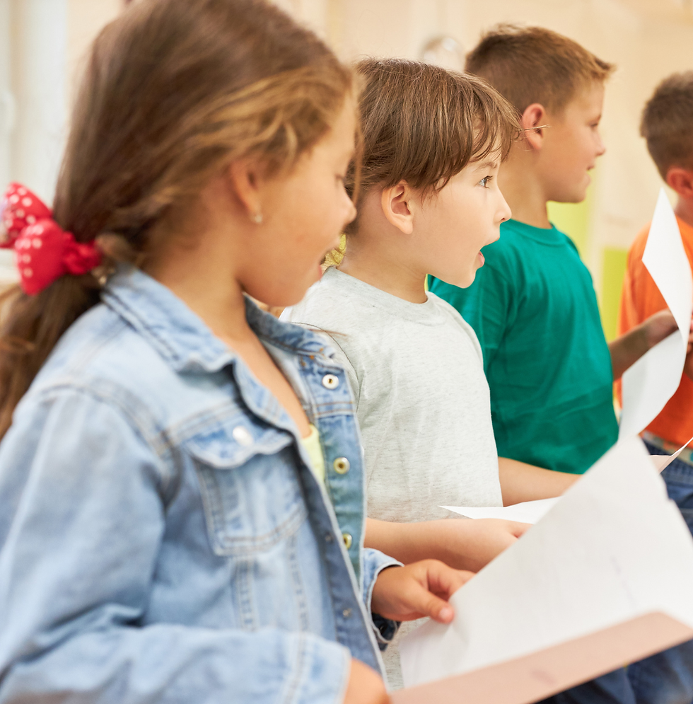 Children singing while holding music.