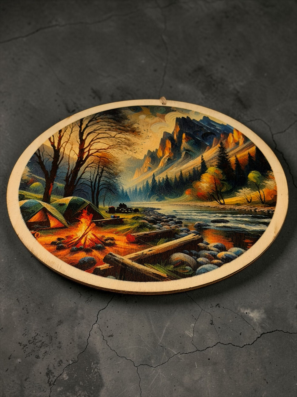 Round wooden wall art with campfire and mountain landscape scene on dark background