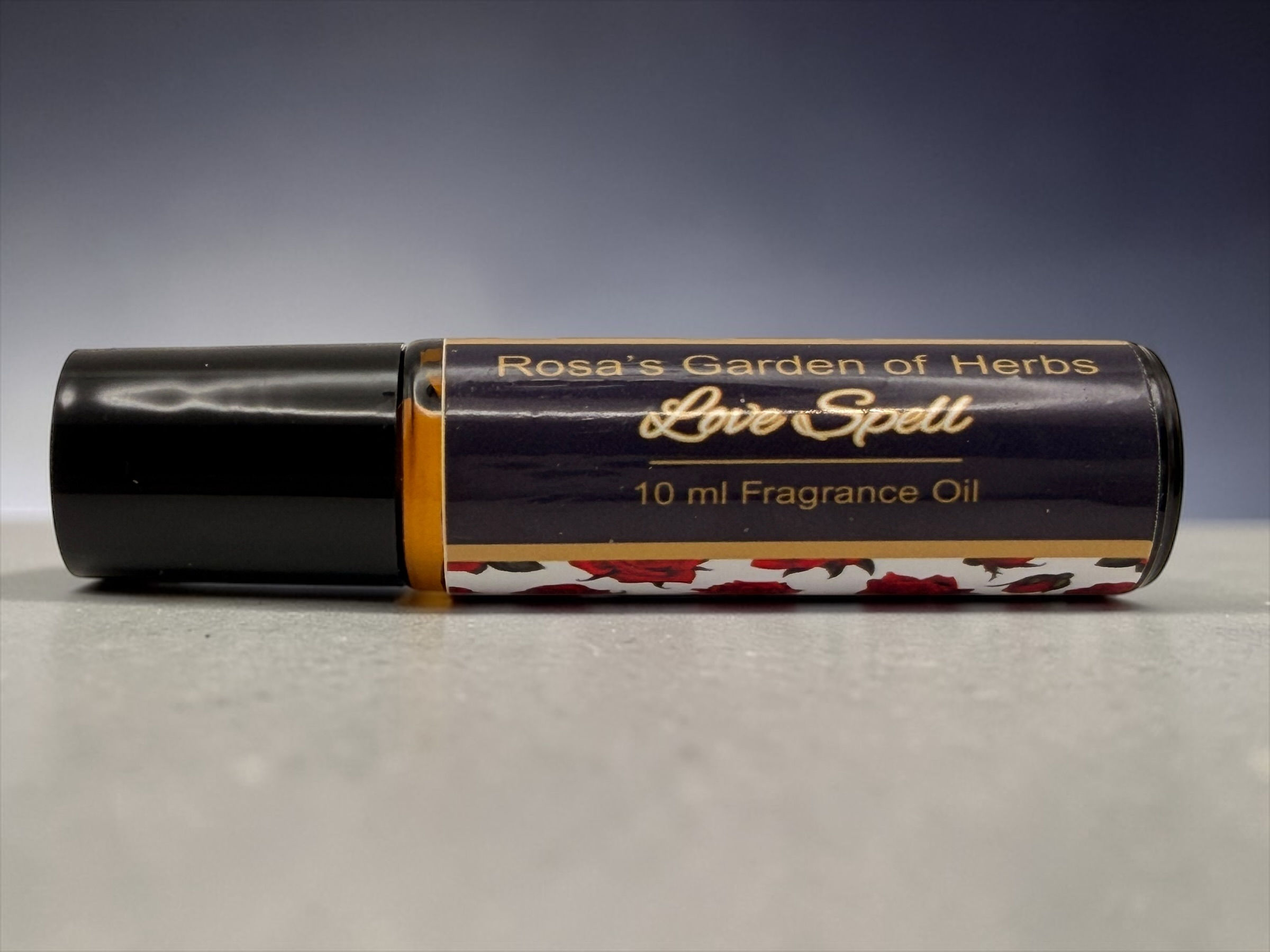 Love Spell fragrance oil roller 10 ml bottle on gray surface with dark gradient background