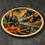 Miniatura: Round wooden wall art with campfire and mountain landscape scene on dark background