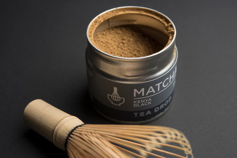a can of matcha kenya black tea drop next to a whisk