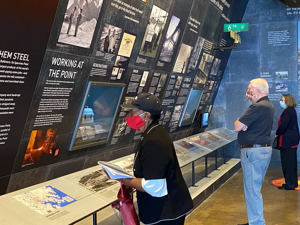 Fire and Shadow exhibition with woman and a man reading exhibition text.
