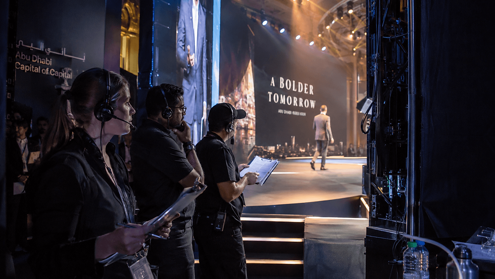 Backstage live event production crew coordinating stage cues and timing in Abu Dhabi
