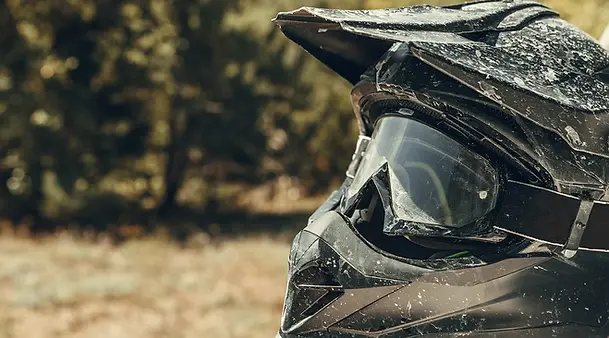 Dirty-motorcycle-motocross-helmet-with-goggles.webp
