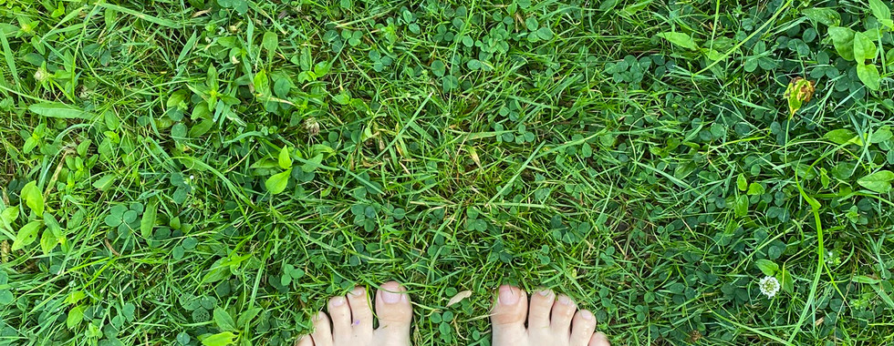 Bare feet in the green grass symbolizing dry, solid ground.