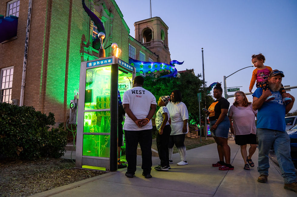 People standing in line at night waiting to get into a Halloween themed interactive art expierence