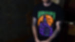 A man with tattoos wearing a Denton Tx Halloween shirt with an illustration of the Denton Courthouse