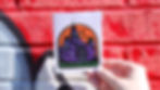 A womans hand holding a sticker with a illustration of the Denton Courthouse