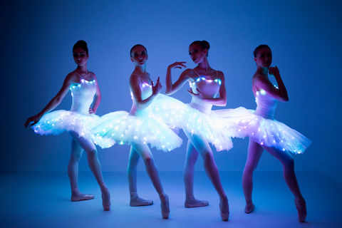 4 ballerinas dressed in white outfits with LED lights added to them