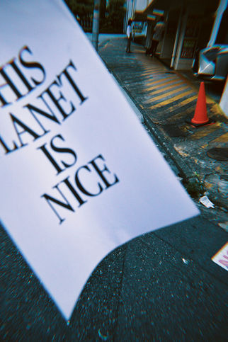 路上にTHIS PLANET IS NICEと書かれた紙が舞っている